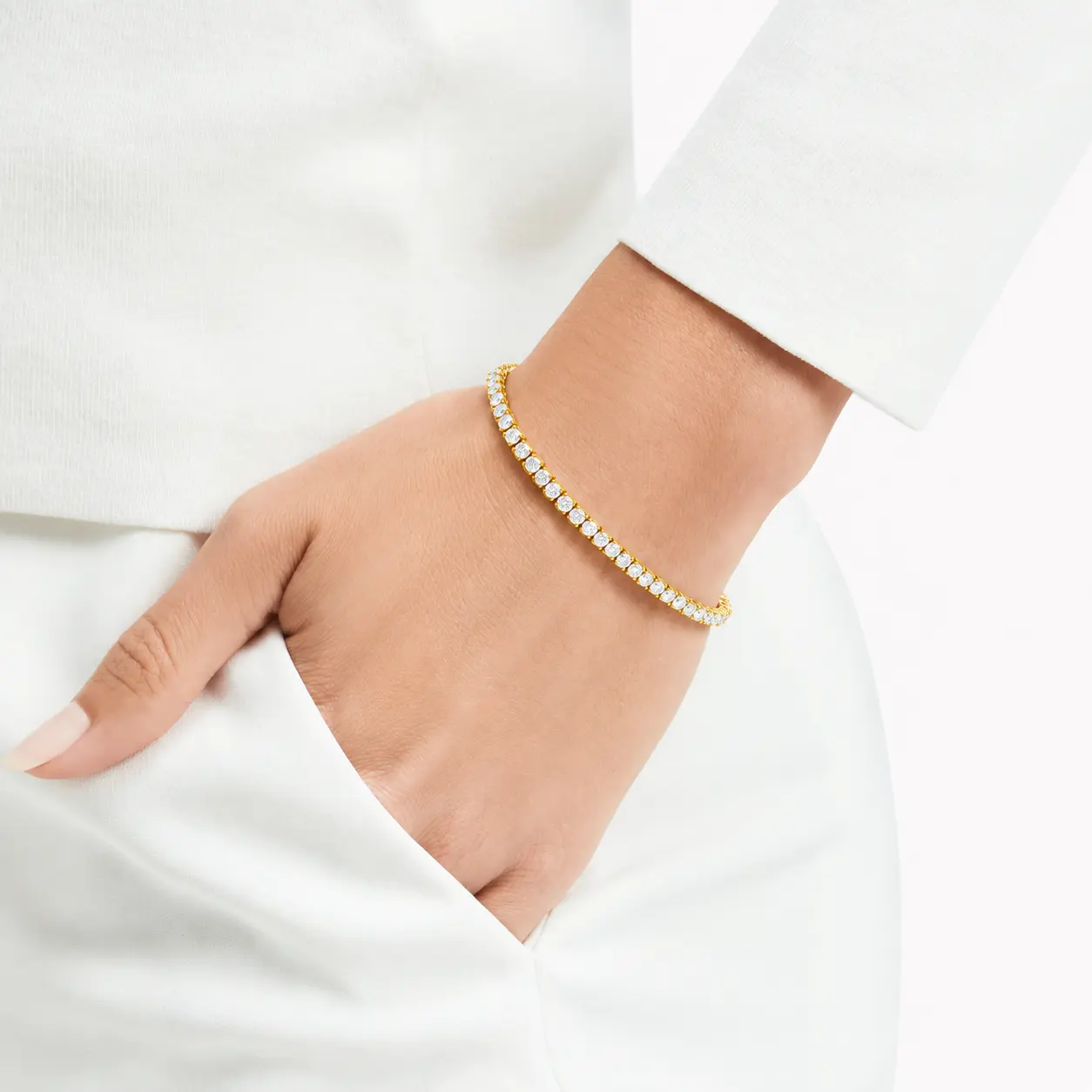 Yellow gold diamond tennis bracelet worn on the wrist